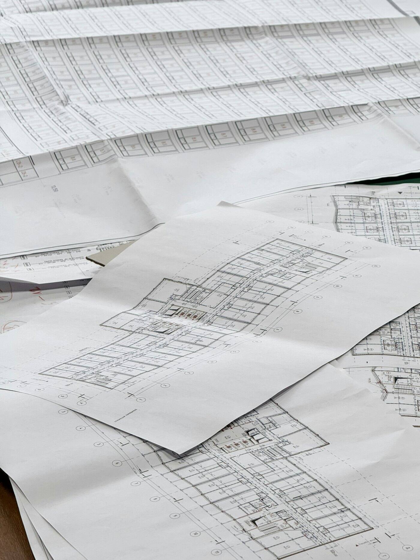 Plans d'architecte étalés sur une table de travail